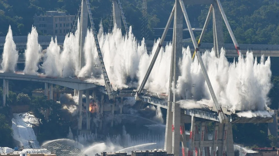 Die im August 2018 teilweise eingestürzte Morandi-Brücke in Genua ist gesprengt worden. Um der aufgewirbelten Staubwolke Herr zu werden, wurden die 4000 Tonnen schweren Trümmer sofort mit Dutzenden Wasserkanonen bespritzt. Beim Einsturz zehn Monate zuvor stürzten 35 Personenwagen und drei Lastwagen in die Tiefe. 43 Menschen kamen ums Leben gekommen. Die 400 Meter lange Brücke war 1969 eingeweiht worden. Jedes Jahr wurde sie von 25 Millionen Autos befahren. (Foto: Keystone/Ansa)