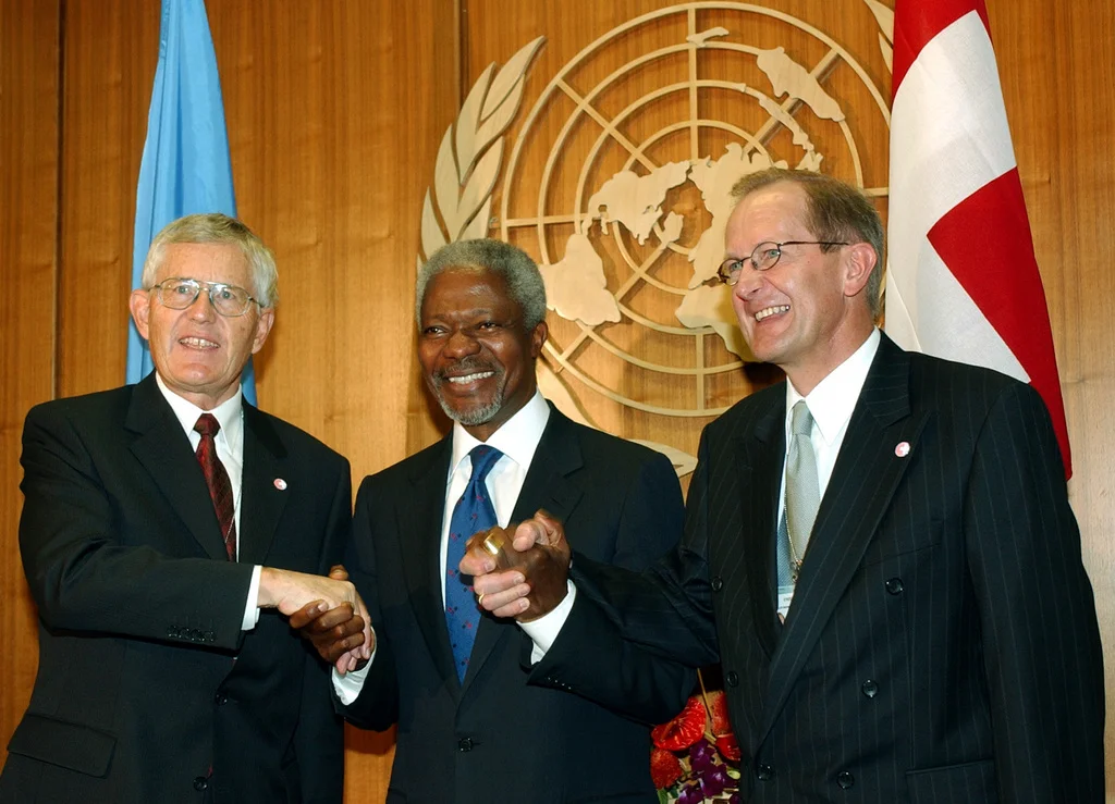 „Die Schweiz ist angekommen. Wir haben lange Jahre darauf gewartet.“ Mit diesen Worten begrüsst Uno-Generalsekretär Kofi Annan die Schweizer Delegation am New Yorker Uno-Sitz. In der Nacht leuchtet das Empire State Building in den Schweizer Farben Weiss und Rot. Am 3. März 2002 hatten 54,6 Prozent der stimmenden Schweizerinnen und Schweizer den Uno-Beitritt befürwortet. Die Stimmbeteiligung lag bei 57,6 Prozent. Zwölf Kantone befürworteten die Vorlage, elf lehnten sie ab. Im Bild: Kofi Annan mit Bundespräs…