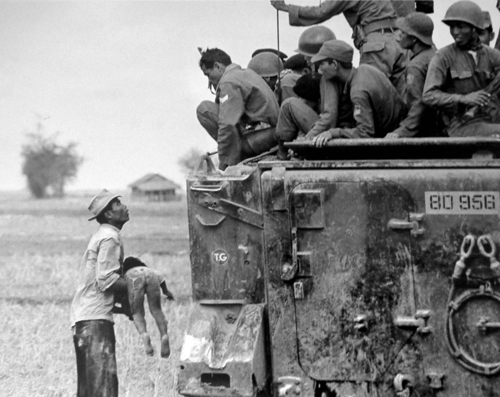 19. März 1964: Ein Vater zeigt amerikanischen Soldaten vorwurfsvoll seinen Sohn, der bei einem US-Angriff ums Leben kam. (Foto: AP/Horst Faas)