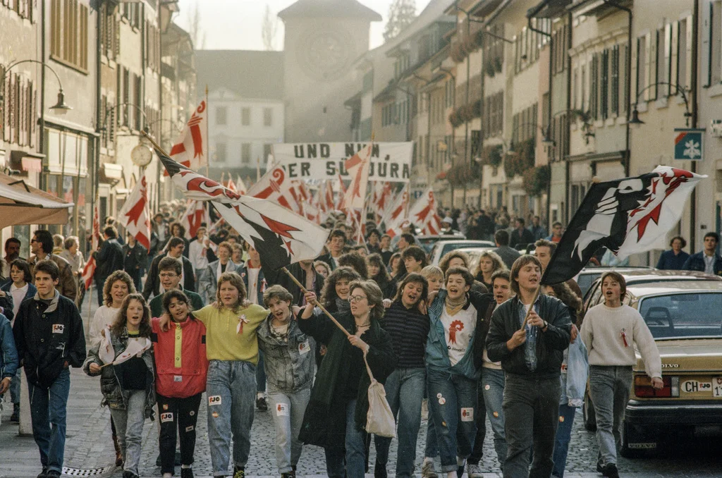 Zum ersten Mal seit Bestehen des Bundesstaates wechselt ein ganzer Bezirk den Kanton. Vor 25 Jahren tritt das bisher bernische Laufental dem Kanton Basel-Land bei. In den Strassen des Hauptorts Laufen wird ausgelassen gefeiert. (Foto: Keystone/Str) Mit der Abspaltung des nördlichen Juras vom Kanton Bern wurde das Laufental zur Enklave. Nach langen, heftigen politischen Auseinandersetzungen entschieden sich die Laufentaler am 12. November 1989 mit 51,7 Prozent der Stimmen für einen Beitritt zum Kanton Basel…