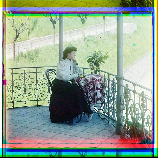 Eine Frau blickt von der Terrasse auf ein Feld. Fotografiert 1905