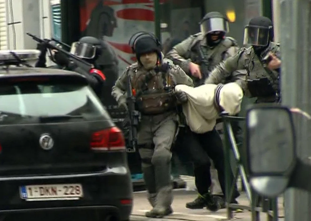 Belgische Polizisten führten am vergangenen Freitag einen Festgenommenen in ein Polizeiauto. Die belgischen Sicherheitskräfte hatten im Brüsseler Stadtteil Molenbeeck vier verdächtigte Terroristen verhaftet. Unter ihnen befindet sich Salah Abdeslam. Er gilt als einer der Attentäter von Paris im vergangenen November. Der Verhaftung sollen laut Augenzeugen mehrere Schusswechsel vorangegangen sein. (Foto: Keystone/VTM/via AP) 