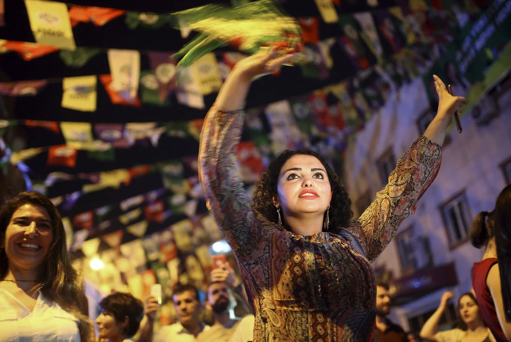 In der vorwiegend von Kurden bewohnten türkischen Stadt Diyarbakir tanzen Frauen auf der Strasse und feiern den Einzug der pro-kurdischen HDP ins Parlament. (Foto: Keystone/AP/Emre Tagegul)