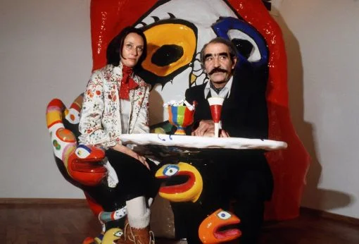 Der in Freiburg/Fribourg geborene Schweizer Maler und Bildhauer schaffte sich vor allem mit maschinenähnlichen Skulpuren einen internationalen Ruf. Das Bild zeigt Tinguely und seine Frau Niki de Saint Phalle am 21. März 1980 in der Galerie Bischofberger in Zürich. Der Tisch, an dem die beiden sitzen, war von Niki de Saint Phalle entworfen worden. Zu Tinguelys bekanntesten Werken gehören der „Fasnachtsbrunnen“ in Basel, die „Heureka“ in Zürich und die „Fontaine Stravinsky“ in Paris. (Foto: Keystone/Str) 