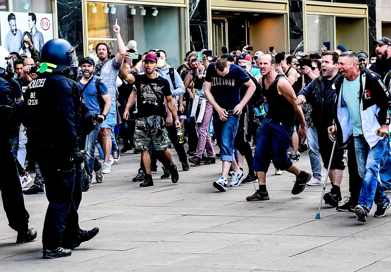 epa08412197 Right wing protestors attack police officers during a gathering on the Alexanderplatz in Berlin, Germany, 09 May 2020. According to a spokesperson of the Berlin police a group of people moved from the surrounding of the so-called 'hygiene demonstration' at the Volksbuehne at Rosa-Luxemburg-Platz to Alexanderplatz. As moving in bigger groups still is prohibited due to the covid-19 security measures police started detaining participants at Alexanderplatz. The motivation of the people to gather wa…