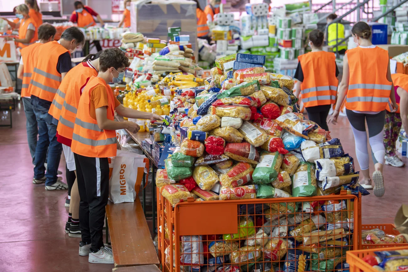 Über hundert freiwillige Helferinnen und Helfer verteilen die Hilfspakete. (Foto: Keystone/Martial Trezzini)