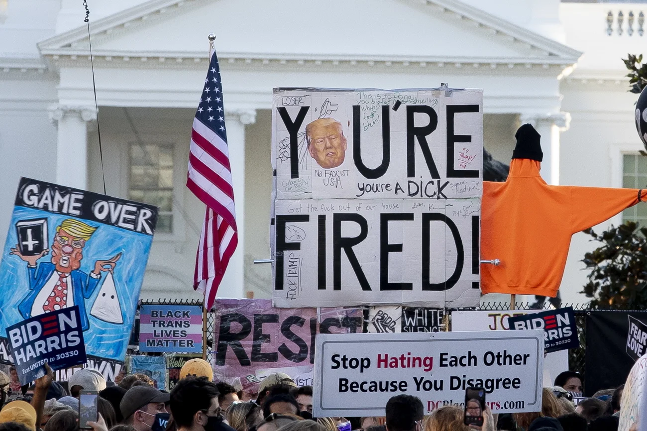 epa08806263 A sign says 'You're Fired', with the White House seen behind, as thousands of people celebrate after news organizations called the US 2020 presidential election for Joe Biden, defeating incumbent US President Donald J. Trump, at Black Lives Matter plaza in Washington, DC, USA, 07 November 2020. EPA/MICHAEL REYNOLDS 