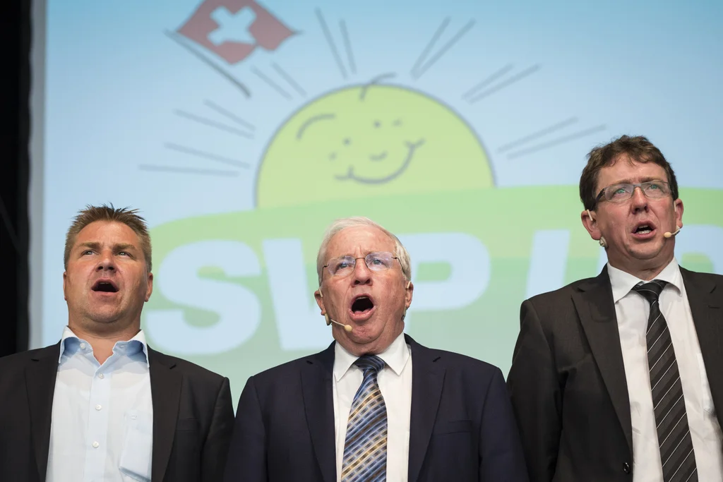 Von links: der abtretende Parteipräsident Toni Brunner, Vizepräsident Christoph Blocher und der wahrscheinlich neue Parteipräsident Albert Rösti. Das Archivbild stammt von der SVP-Delegiertenversammlung am 22. August 2015 in St. Luziensteig, Maienfeld. Zum Wahlauftakt singen die drei SVP-Politiker die Nationalhymne (Foto: Keystone/Gian Ehrenzeller). 