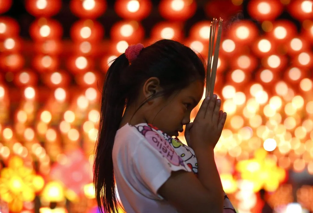 Ein Thai-Mädchen bittet vor Beginn des Frühlingsfestes im Siam Thai Tien Kong-Schrein ausserhalb von Bangkok um Glück und Wohlstand. (Foto: Keystone/EPA/Rungroj Yongrit)