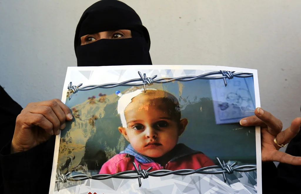 Eine jemenitische Frau hält ein Plakat bei einer Antikriegs-Kundgebung bei den Uno-Büros in Sana'a, an der Hunderte teilgenommen haben sollen. Sie verlangten mit Blick auf die Verhandlungen von Stockholm ein Ende des seit mehr als dreieinhalb Jahren andauernden Kriegs. (Keystone/EPA, Yahya Arhab)