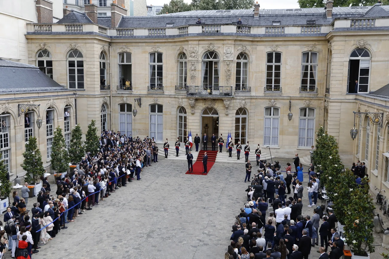 Stabübergabe im Hôtel Matignon. Links auf dem roten Teppich der abtretende Premierminister Édouard Philippe, rechts neue Jean Castex. Links und rechts im Bild: Angestellte der Ministerien.  (Foto: Keystone/EPA/Thomas Samson)