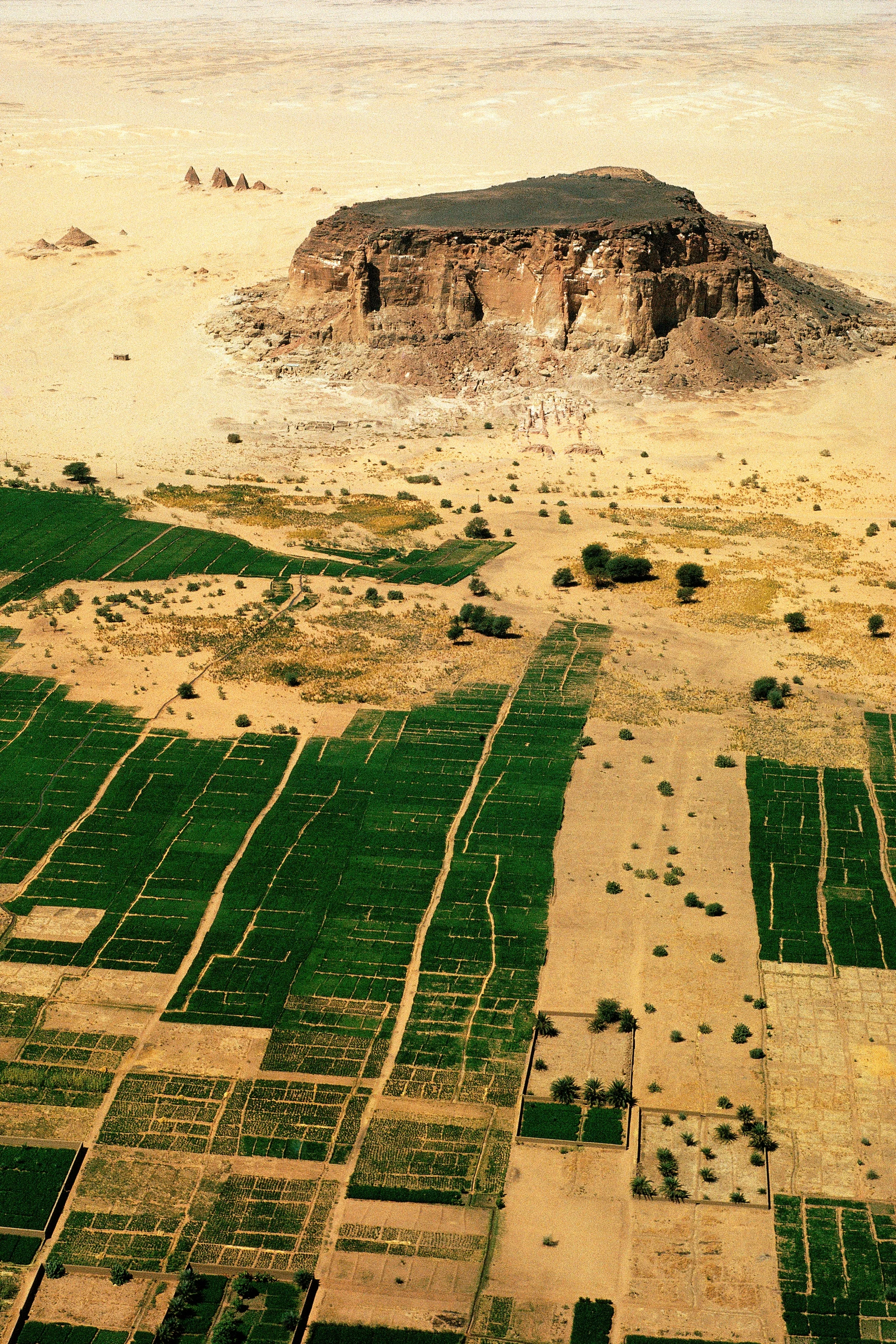 Der Sudan unterschrieb die Welterbekonvention 1974 – noch bevor sie in Kraft trat. Trotzdem musste er lange bis zur Auszeichnung eines ersten Kandidaten anstehen.
Gebel Barkal und die umliegenden archäologischen Stätten (Aufnahmejahr 2003) waren freilich auch hochkarätig genug, ohne Frage eine Kandidatur von Welterbe-Statur – wenn es denn schon Welterbe gab. Gebel Barkal, der heilige Berg der Kuschiten, zwanzig Kilometer stromabwärts vom vierten Nil-Katarakt am linken Ufer, war der Götter- und Regierungss…