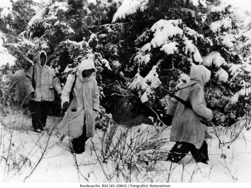 Ein deutscher Spähtrupp arbeitet sich durch einen tief verschneiten Wald. (Bild: Deutsches Bundesarchiv, 183-J28642, Januar 1945, Rottensteiner)