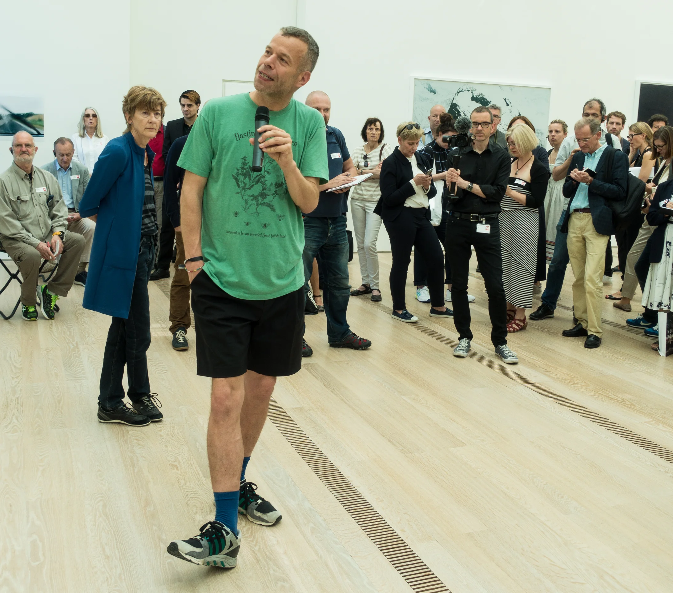 Wolfgang Tillmans erläutert ein Werk, links hinter ihm Theodora Vischer, Senior Curator der Fondation Beyeler, mit kuratorischer Fussstellung. Den Hintergrund bilden die Kunstexperten diverser Medien. Foto: journal21.ch/S.W.