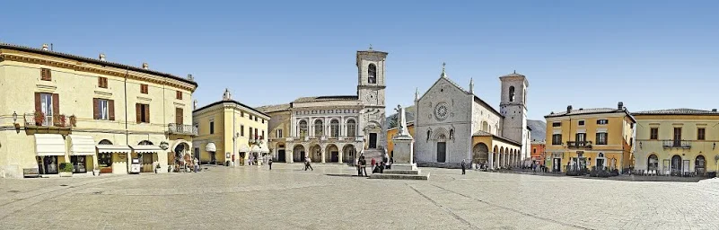 Norcia vor dem Erdbeben: ein Foto des Fremdenverkehrsvereins. Im Vordergrund die Statue des Heiligen Benedikt, im Hintergrund die jetzt zerstörte Kathedrale. 