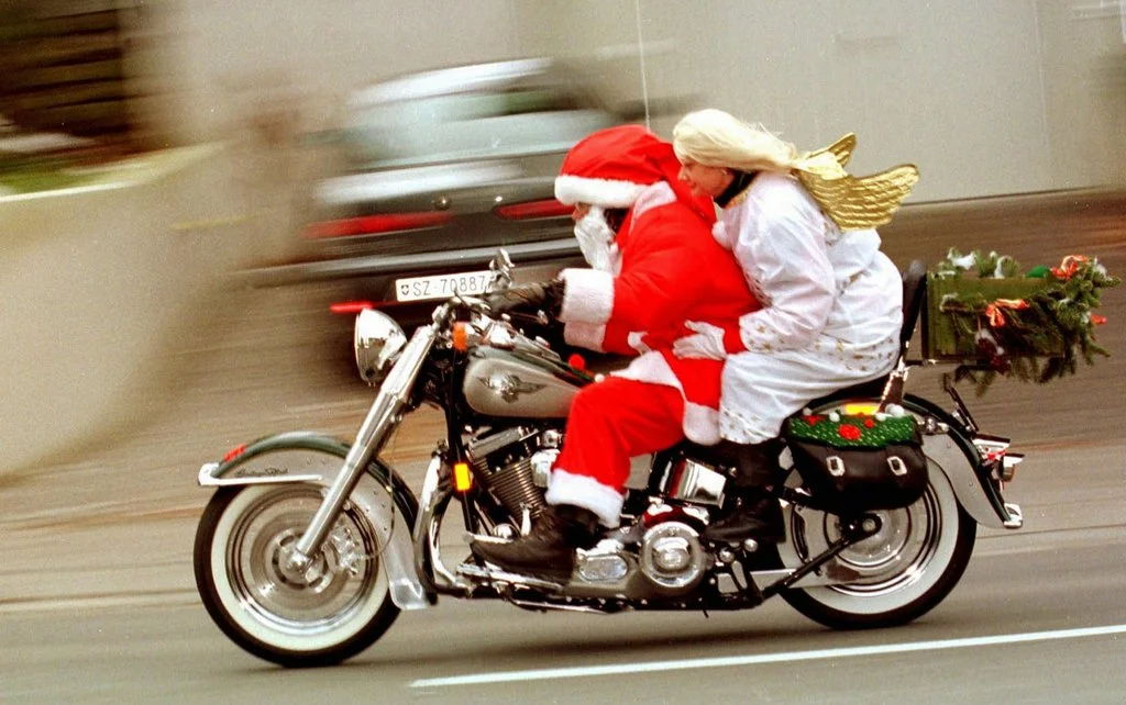 Der eilige heilige St. Nikolaus mit Engel donnert bereits am Samstag, 4. Dezember 1999, auf seinem schweren Motorrad mit erfreulich leichter Begleitung durch Zürich, damit kein Kind leer ausgeht. (Foto: Keystone/Walter Bieri)